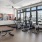 Spacious well lit fitness center with cardio equiptment and weight machines.