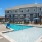 Sparkling blue pool with a sundeck and plenty of lounge chairs.