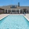 Sparkling blue pool with a sundeck and plenty of lounge chairs.