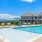 Sparkling blue pool with a sundeck and plenty of lounge chairs.